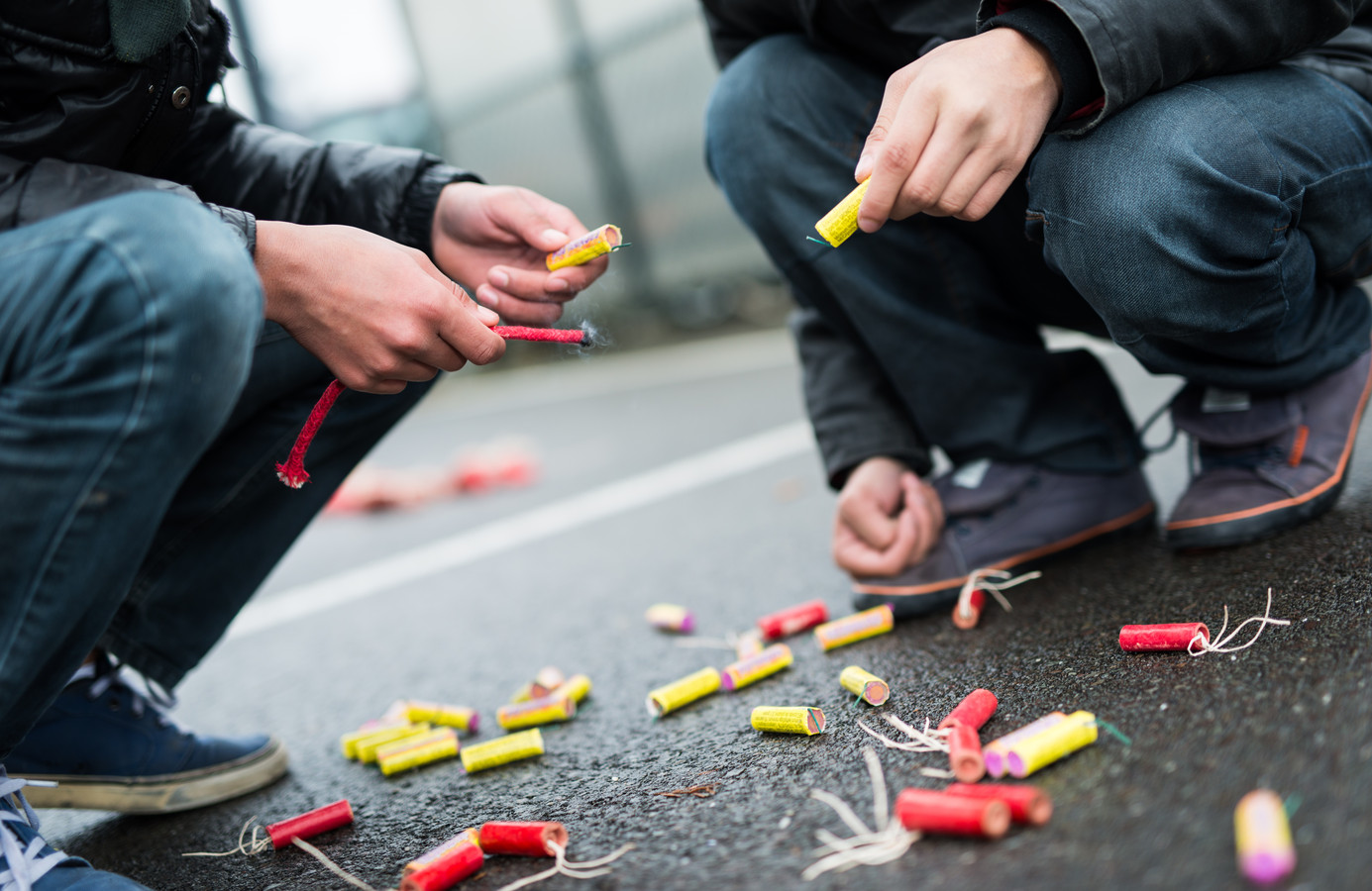 Kinderen steken rotjes af op straat.