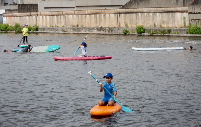 Kinderen uit het Laakkwartier op supboards in het water bij de Binckhorst.