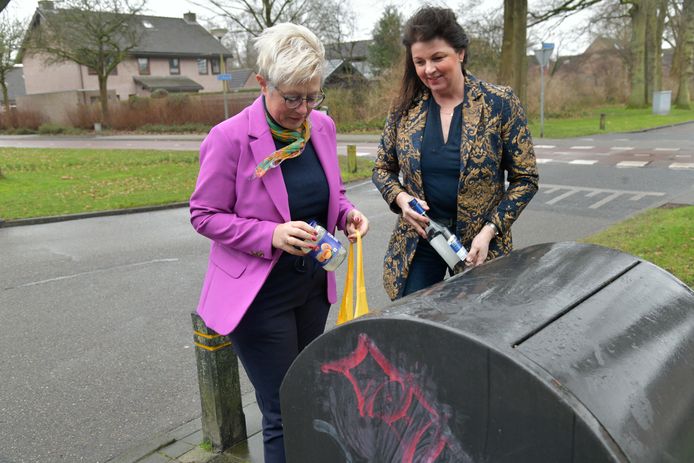 Corrie Jansen en Petra van Olst (beiden Gemeentebelang) bij de afvalcontainer.