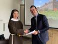 Abdis zuster Rebecca Braun schudt de hand van wethouder Sidney van den Bergh na ondertekening van de overeenkomst tussen de zusters Clarissen en de gemeente Oss.