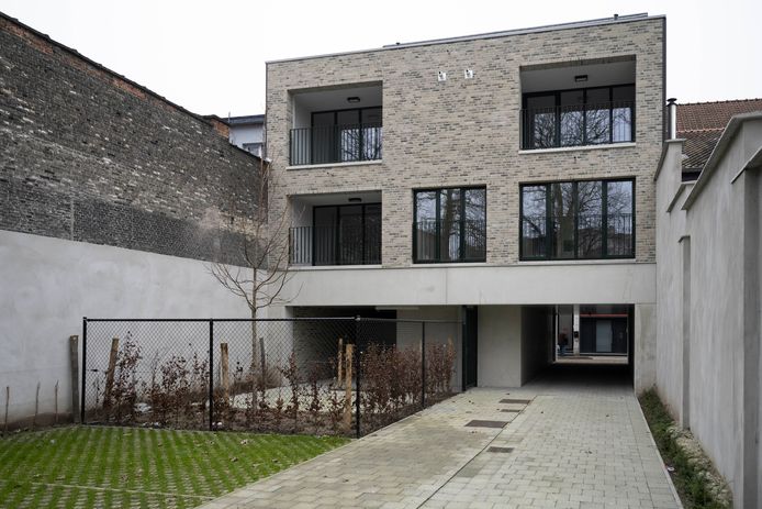 De nieuwbouwappartementen, met een doorgang naar de tuin van de dekenij.
