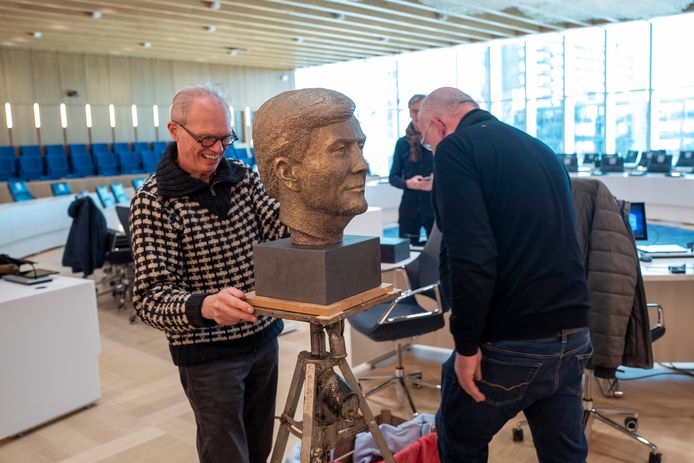 Kunstenaar Niko de Wit brengt het bronzen portret van koning Willem-Alexander terug de raadszaal in.
