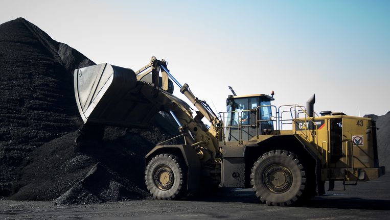Een bulldozer verwerkt kolen in de haven van Amsterdam. Beeld ANP