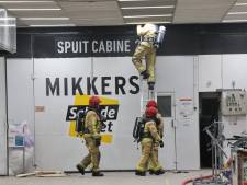 Brand in autospuiterij in Veldhoven, vlammen slaan uit het dak