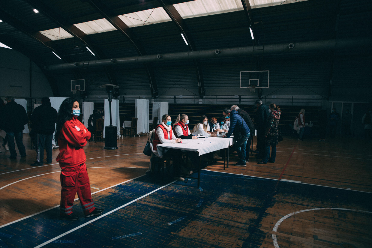 Bij binnenkomst in de sporthal in Kragujevac vindt eerst de registratie plaats, daarna volgen een gesprek met een arts (linksachter op de foto) en de prik. Beeld Marlena Waldthausen