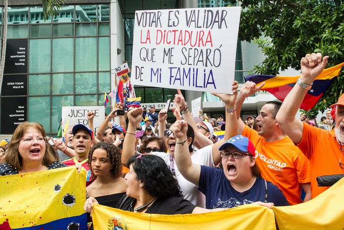 Venezolanen in Miami protesteren tegen de verkiezingen in Venezuela. Op het bord staat 'Stemmen is de democratie steunen die me van mijn familie scheidde'.