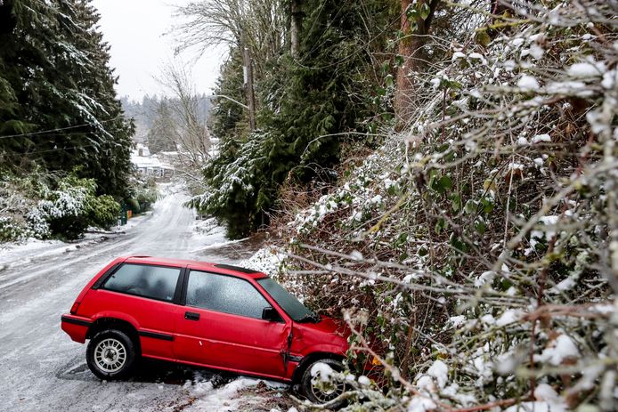 Abandoned car in trouble in Seattle due to weather.