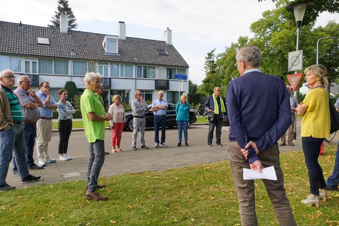Anne Regts van het IVN (in gele shirt) geeft de bewoners van de Helmondse Boerhaavelaan tijdens een rondleiding uitleg over welke bomen verdwijnen en wat ervoor terug komt.