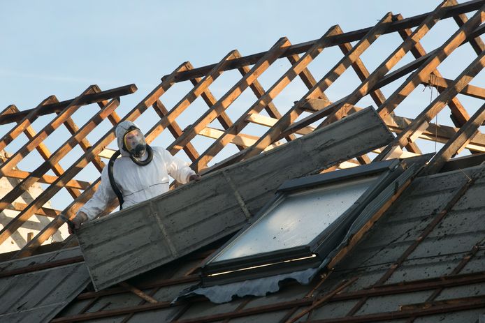 Het verwijderen van asbestplaten van een dak. Beeld ter illustratie.