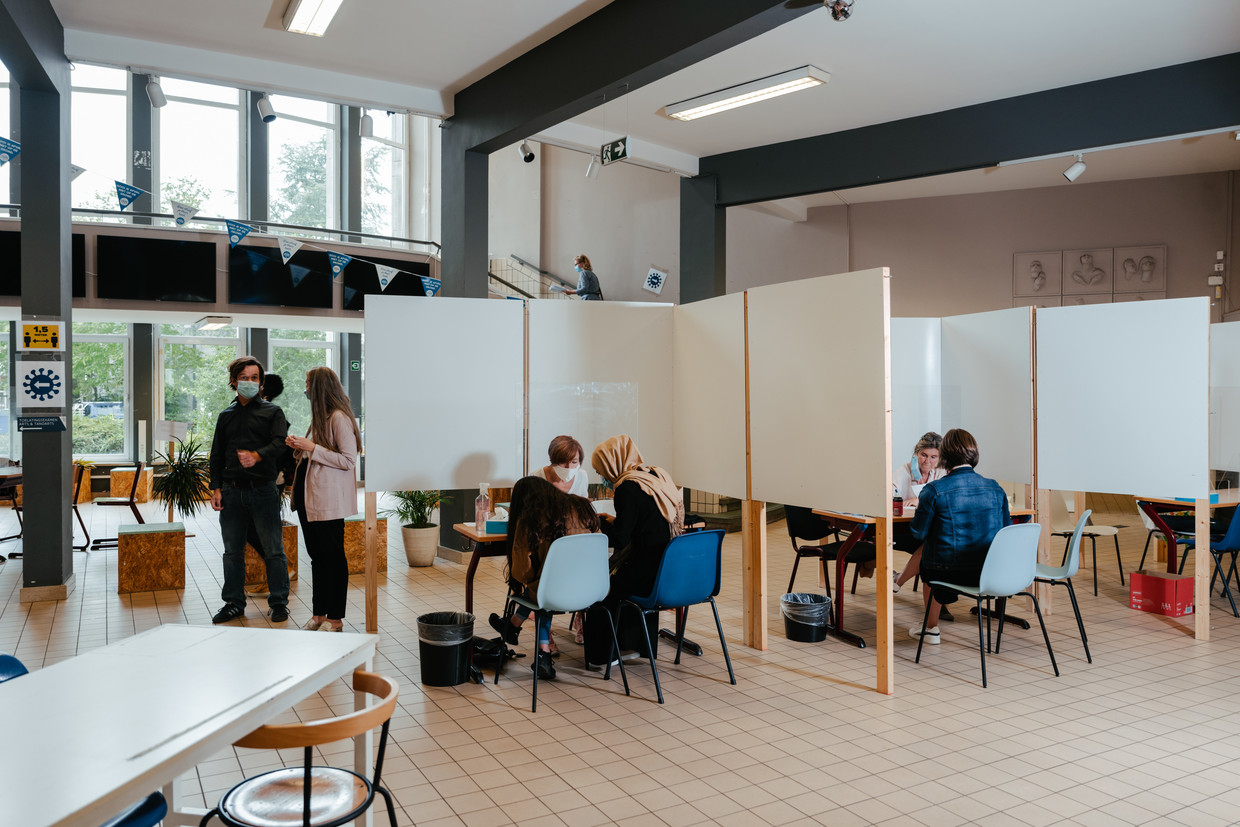 Nieuwe leerlingen schrijven zich in aan het Stedelijk Lyceum Olympiade in Antwerpen. Maar niet voordat ze hun handen hebben ontsmet. ‘Ik denk dat hoe harder je strest over corona, hoe groter de kans is dat je ziek wordt’, zegt zesdejaars Diana Marycheva. Beeld Damon De Backer