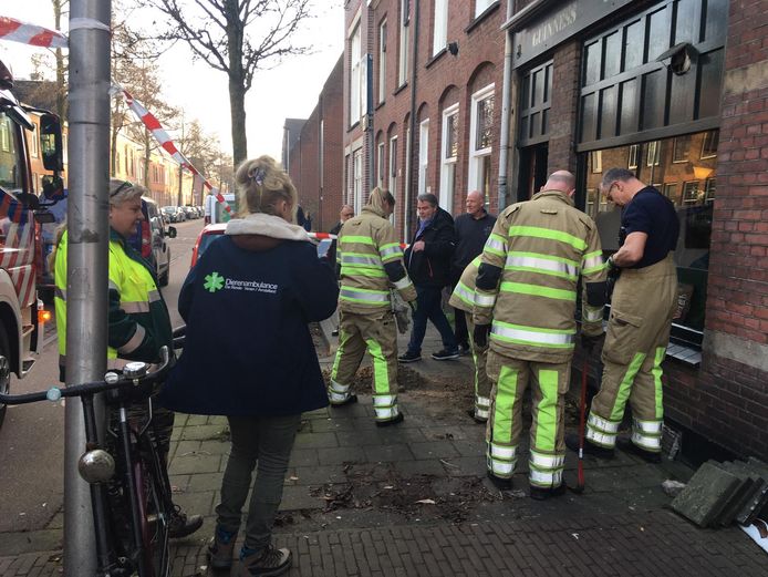 Brandweerlieden proberen de kat te bevrijden uit zijn benarde positie.