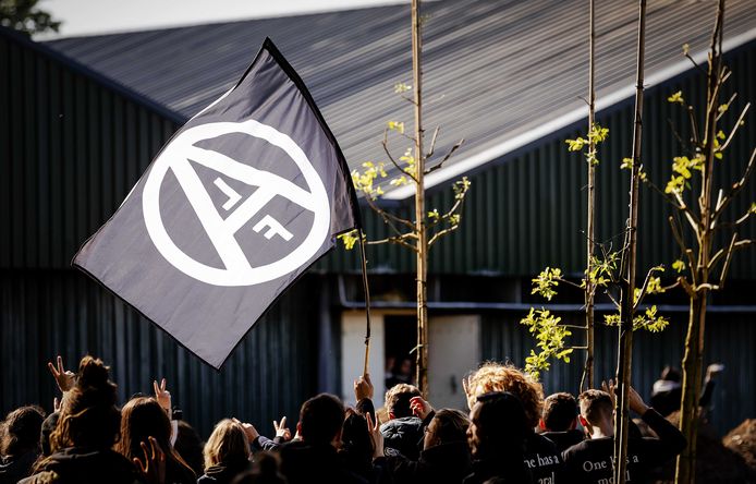 De actievoerders zwaaien met een vlag van het Animal Liberation Front (ALF).