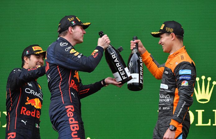Lando Norris (r), Max Verstappen en Sergio Pérez proosten op het podium.