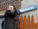 Wethouder Kees Diepeveen plaatst op de Ganzenmarkt het eerste van een nieuwe reeks straatnaamborden in Utrecht. Score: 4,5 Domtorentjes.