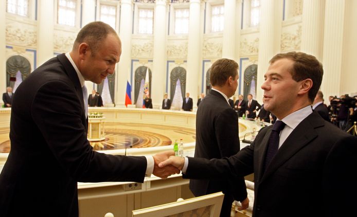 Andrey Melnichenko (l) schudt handen met Dmitri Medvedev.