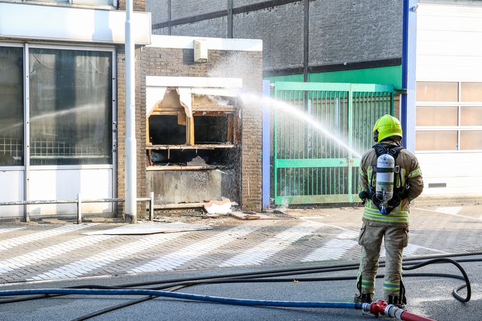 De brandweer blust de brand die ontstond bij de loods.