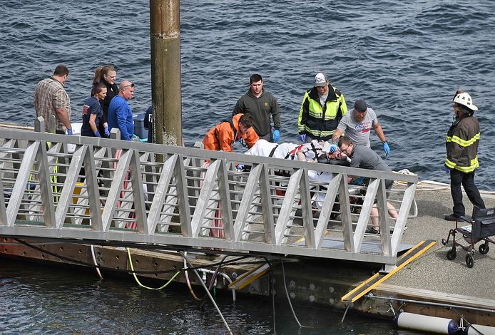 Hulpverleners brengen een gewonde passagier van een van de twee gecrashte vliegtuigen aan wal in Ketchikan, Alaska.