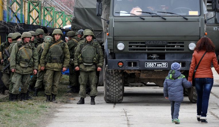 Militairen op de Krim naast een vrachtwagen van Russische makelij. Beeld afp