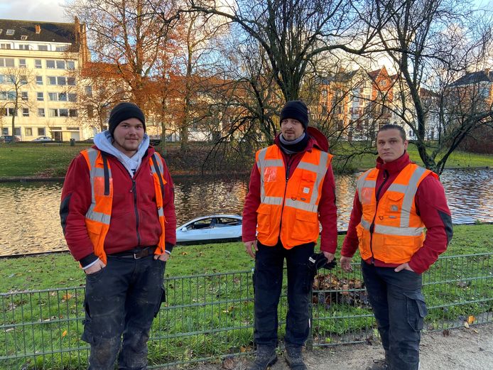 Enkele van de stadsarbeiders, onder wie Vladimir Vallé (rechts), die de vrouw uit het water hielpen.