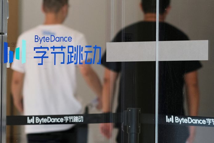 Mensen wandelen in Peking langs het logo van ByteDance, het bedrijf dat eigenaar is van de populaire app TikTok.