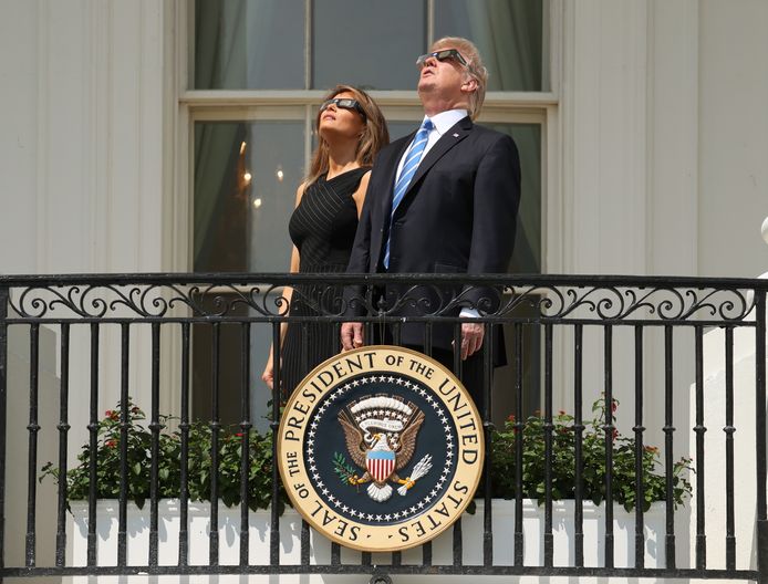 President Donald Trump en first lady Melania Trump kijken met speciale eclipsbrillen naar de zonsverduistering.