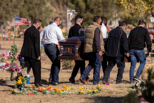 Een rouwende familie met een aan Covid-19 overleden familielid op een kerkhof in Texas.