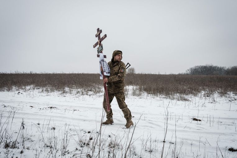 Een Oekraïense soldaat draagt het kruis dat op het graf van zijn beste vriend zal worden geplaatst, die sneuvelde tijdens de strijd om Bachmoet.  Beeld AFP