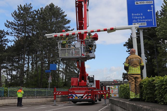 De brandweer hangt de balk weer terug nadat er weer een vrachtwagen tegenaan is gereden.