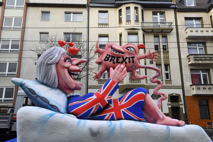 Bij de carnavalsoptocht in Düsseldorf rijdt een praalwagen voorbij waarmee de draak wordt gestoken met de Britse premier Theresa May die een Brexit baart. Foto Patrik Stollarz