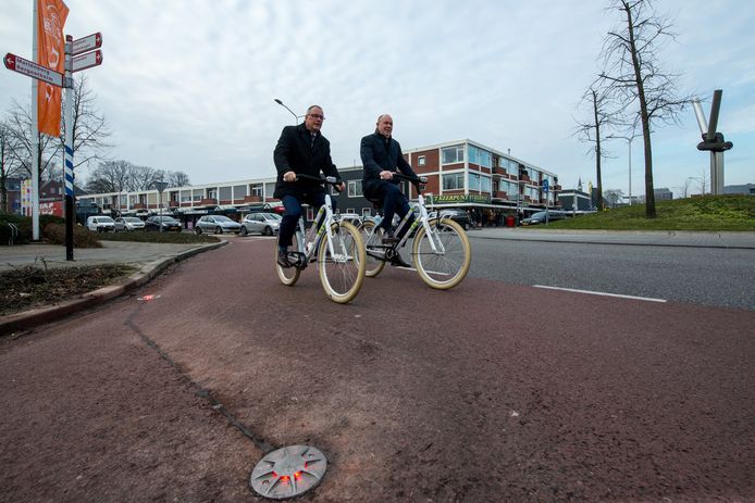 Wethouder Jannes Janssen (links) en gedeputeerde Bert Boerman volgen de rode en daarna groene lichten in de fietsstrook op de rotonde.