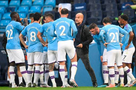 Pep Guardiola (m) instrueert de spelers van Manchester City.