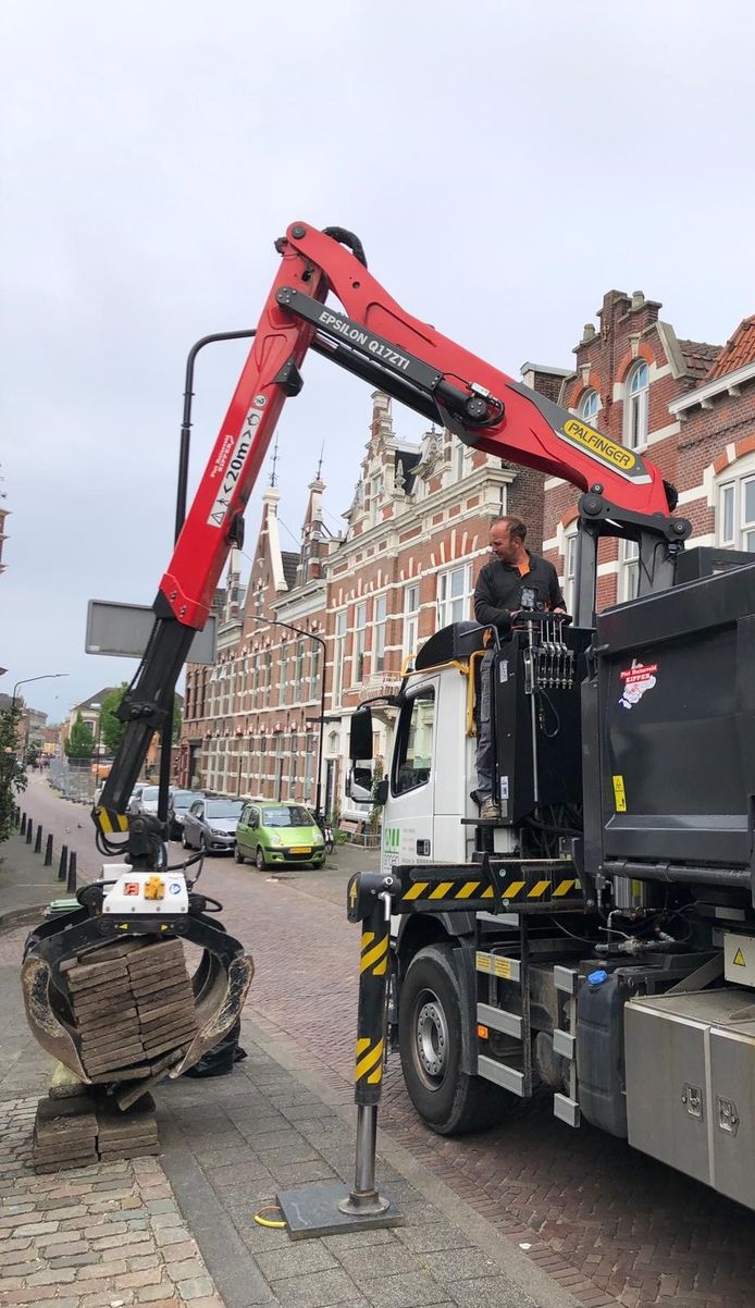 Een kraan haalt tegels op.