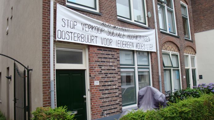 Het spandoek op de woning van bewoner Jos Schuurman: ‘Ach Mitros! Stop verkoop sociale huurwoningen, Oosterbuurt voor iedereen #DoesLief.’