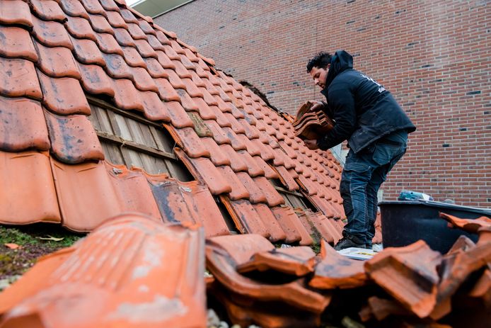 Dakdekkers aan het werk. Storm Eunice heeft voor flinke schade aan onder meer woningen en bedrijfspanden gezorgd.