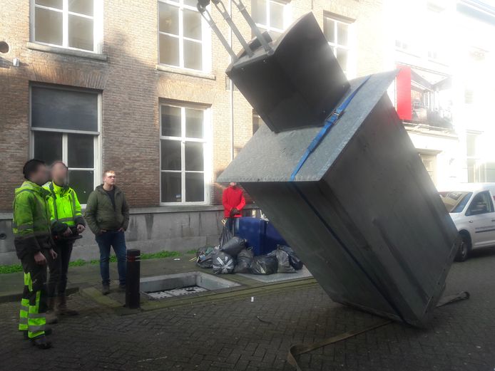 De gevallen container in Den Bosch wordt overeind gehesen om alsnog leeg te worden gemaakt.