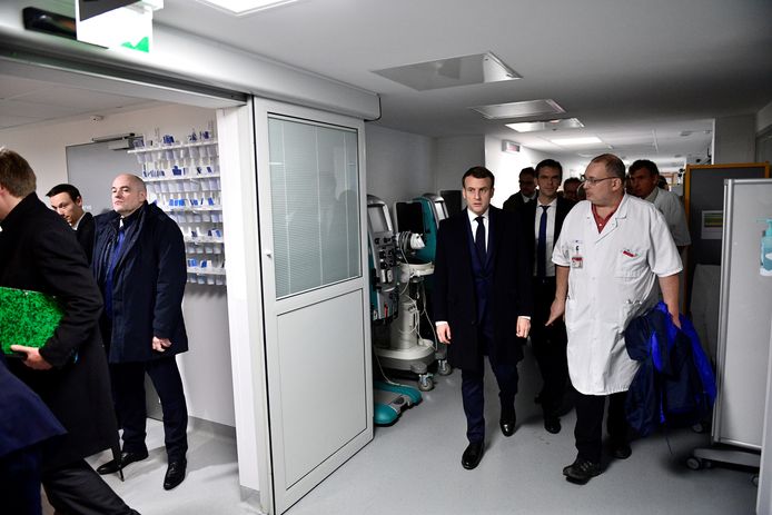 Macron in gesprek met artsen in het  universiteitsziekenhuis Pitié-Salpêtrière in Parijs, waar de eerste Franse coronapatiënt is overleden.