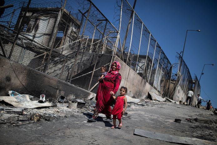 Een moeder met twee kinderen in het uitgebrande vluchtelingenkamp van Moria