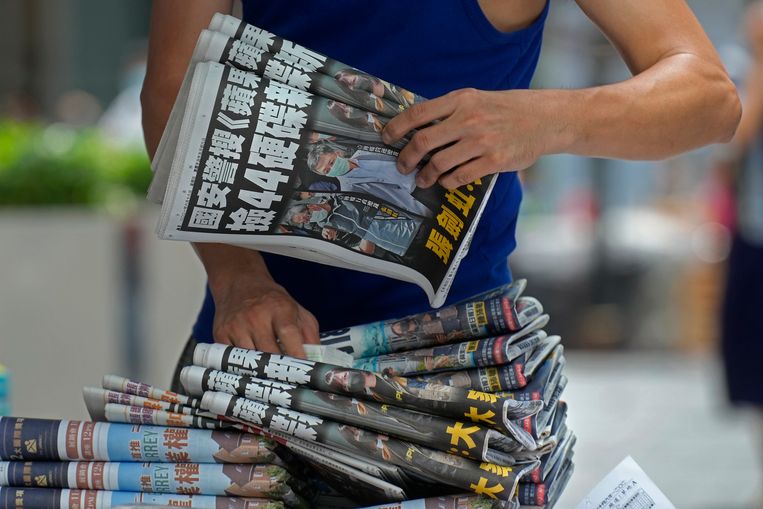 Un vendedor ambulante con un gran paquete de copias del Apple Daily.  Imagen AP