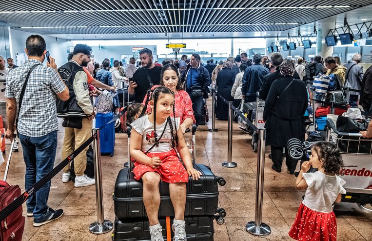 Reizigers schuiven aan op Brussels Airport om op vakantie te vertrekken met het vliegtuig. Beeld Tim Dirven