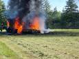 De oogstmachine staat aan brand in een weiland in Aalten.