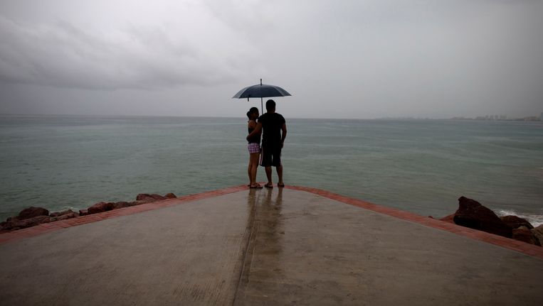 Een koppel staat op de uitkijk in Puerto Vallarta, terwijl orkaan Patricia dichterbij komt. Beeld AP