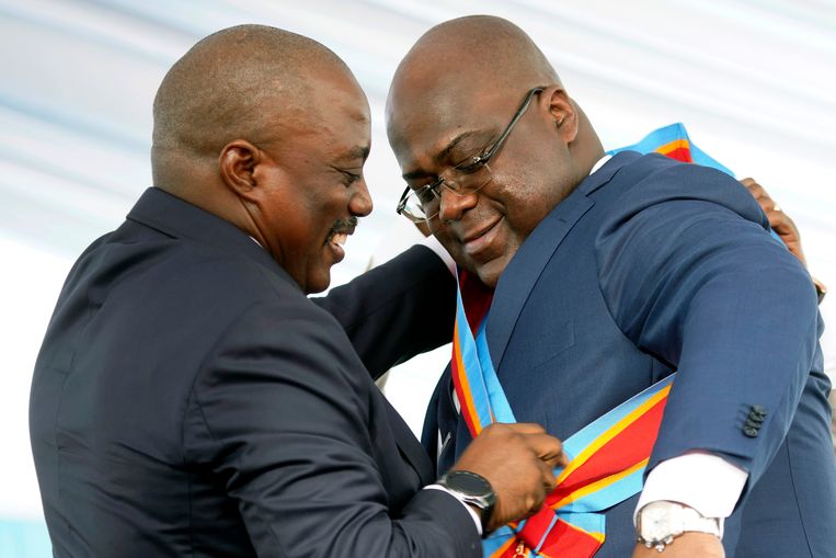 Inhuldiging Congolese President Felix Tshisekedi. Hij krijgt de presidentiële sjerp omgehangen door vertrekkend president Joseph Kabila.  Beeld AP Photo/Jerome Dela