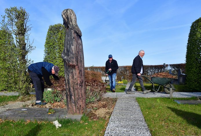 De vrijwilligersploeg aan de slag op het kerkhof van De Heen. Links een hoog houten Christusbeeld, gemaakt door houtkunstenaar Peter de Koning.