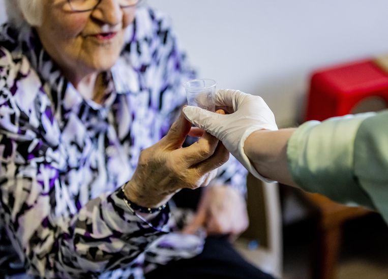 Een bewoner in een verzorgingshuis krijgt medicijnen.  Beeld ANP /  ANP