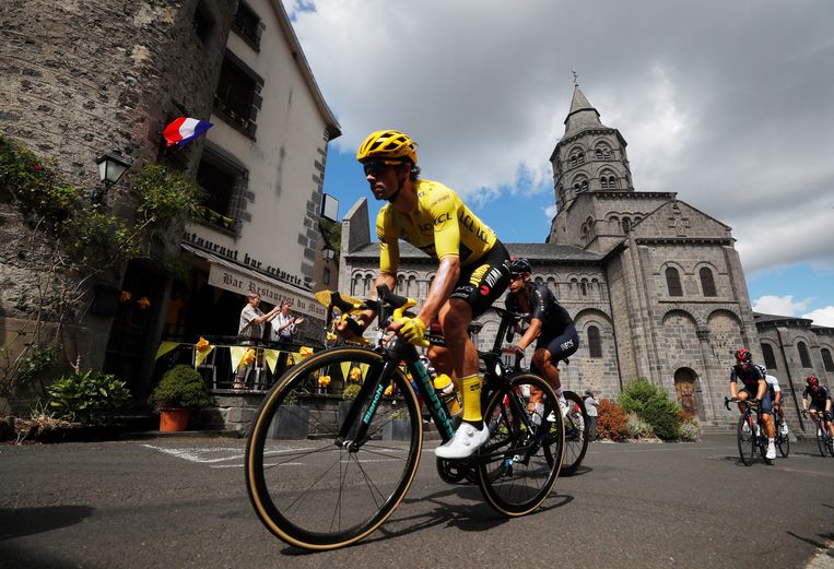 Roglic zoeft door een dorpskern in de Cantal, tijdens rit 13 in de Tour. Beeld REUTERS