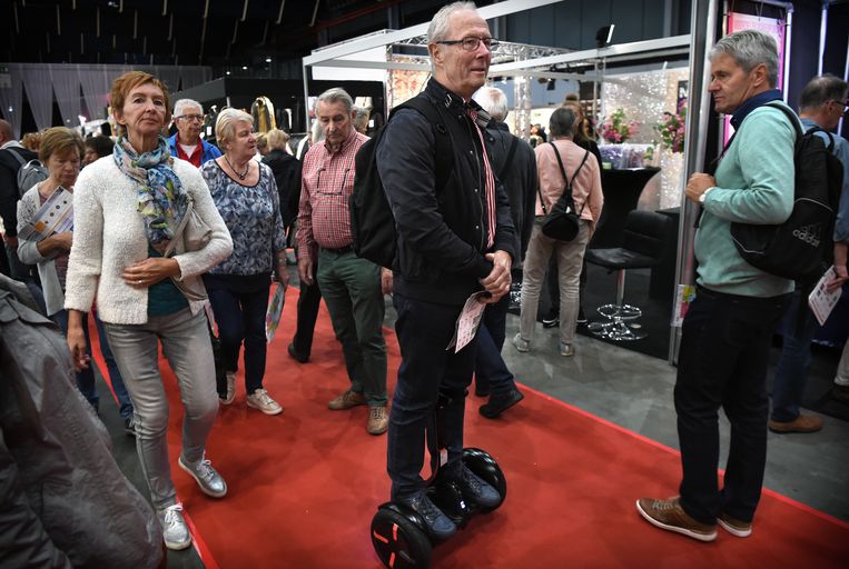 Een bezoeker rijdt met een Segway over een 50+ beurs. Beeld Marcel van den Bergh