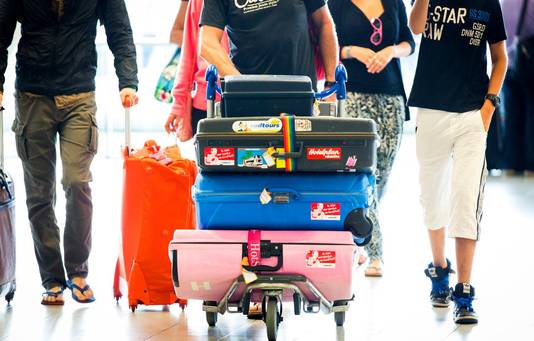Reizigers met koffers op Schiphol