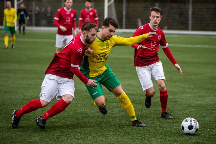Dion Strijdveen (Wijhe, links) in duel met Dennis Willemsen van Overwetering. De bezoekers uit Wijhe wonnen deze keer de derby in Olst: 1-2.