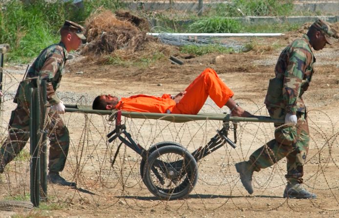Februari 2002: Amerikaanse dienstplichtigen brengen een geketende Guantanamo-gevangene op een draagberrie naar een verhoorplek.