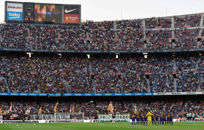 Spelers van FC Barcelona (r) en Real Betis tijdens de 1 minuut stilte voorafgaand aan de wedstrijd ter nagedachtenis aan de slachtoffers van de terreuraanslagen. Daarbij vielen 14 doden en ruim 100 gewonden.